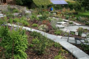 The garden is terraced with traditional stone walls capped with slate slabs that