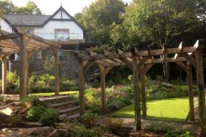 Climbers on pergola include Wisteria, climbing roses and clematis.