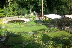 The curved grass terraces respond to the circular shape if the pond