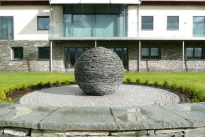 The stone globe sculpture is viewed from the living room & balcony with the back